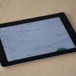 A digital tablet showing a web analytics dashboard with graphs and charts.