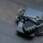 Close-up of a smartphone wrapped in a chain with a padlock, symbolizing strong security.
