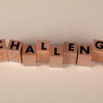 Wooden blocks arranged to spell 'Challenge' against a neutral backdrop, symbolizing overcoming obstacles.