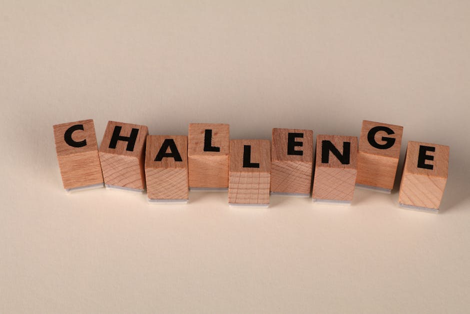 Wooden blocks arranged to spell 'Challenge' against a neutral backdrop, symbolizing overcoming obstacles.