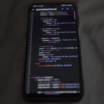Close-up of a smartphone showing Python code on the display, showcasing coding and technology.