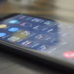 Close-up shot of a smartphone screen showing various app icons, indicating digital technology use.