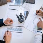 Business team analyzing financial charts and graphs during a collaborative meeting.