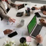 Business team working collaboratively at a modern office desk with charts and laptop.